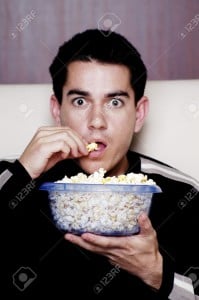 3192526-Man-eating-popcorn-while-watching-movie--Stock-Photo